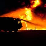 a fire truck putting out a fire at night