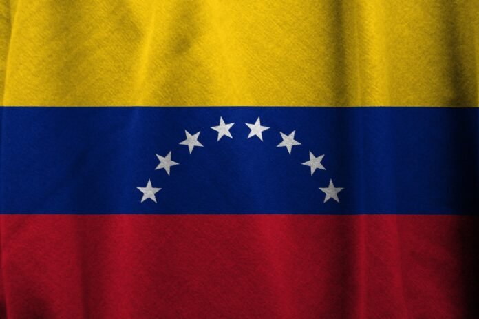 The Venezuelan flag, featuring three horizontal stripes of yellow, blue, and red. The blue stripe contains eight white stars arranged in a semi-circle in the center of the flag.