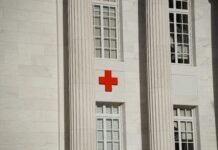 The Truth About USAID: How Political Agendas Shape Public Perception Exterior of a white marble building with a red cross symbol, representing humanitarian aid and emergency medical services.